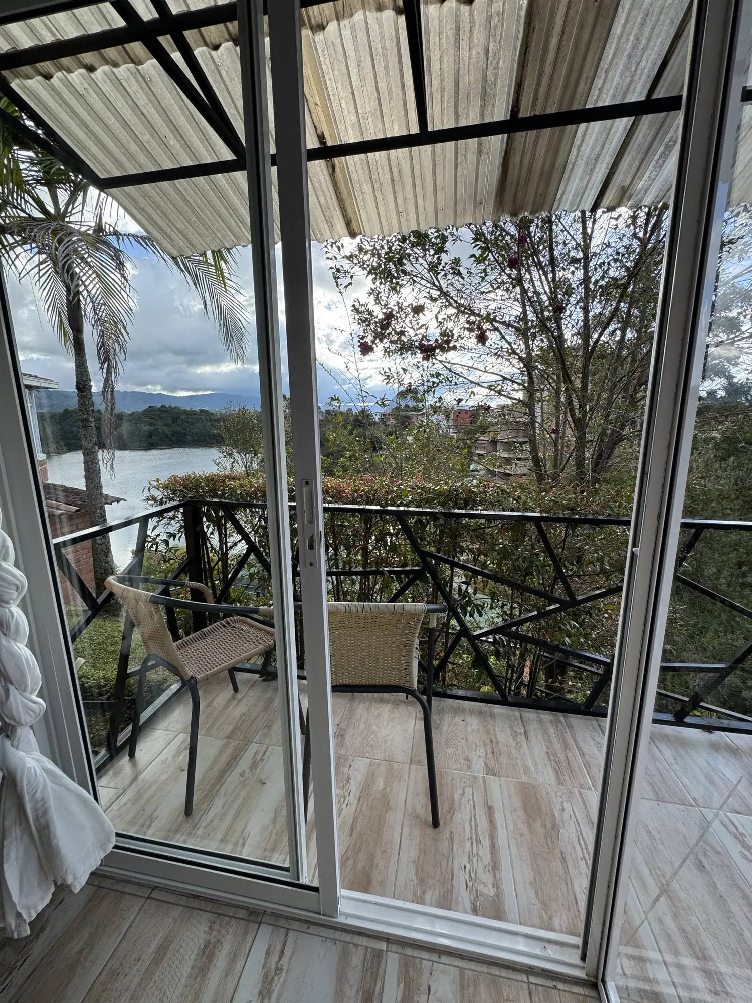 Habitación Caoba con vista, con amplios ventanales y balcón hacia el embalse.